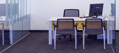 Desk, chair and computer in office setting